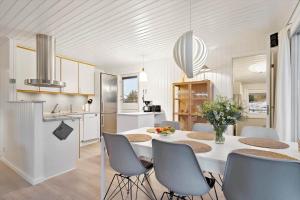 a kitchen and dining room with a white table and chairs at 278-Ringkobing-Fladsbjergvej-54 in Klegod