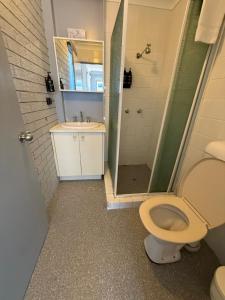 a bathroom with a shower and a toilet and a sink at Surf Beach Motel Tweed in Tweed Heads