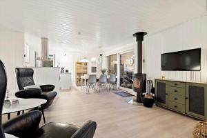 a living room with a fireplace and a living room and a kitchen at 278-Ringkobing-Fladsbjergvej-54 in Klegod