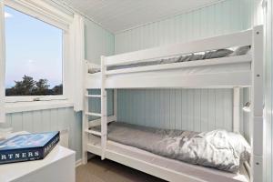 a bedroom with two bunk beds and a window at 278-Ringkobing-Fladsbjergvej-54 in Klegod
