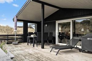 a patio with chairs and a table on a deck at 278-Ringkobing-Fladsbjergvej-54 in Klegod