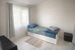 a small bedroom with a bed and a window at Jaunas Ilgas in Medumi