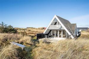 a small house sitting on top of a hill at 260-Ringkobing-Vestklitvej-13 in Klegod