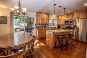 a kitchen with wooden cabinets and a table with bar stools at Lake Forest Glen # 142 in Tahoe City
