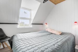 a bedroom with a bed and a window at 273-Ringkobing-Nordso-Ferievej-28 in Nørre Lyngvig
