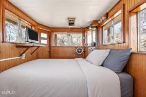 a bedroom with a bed and a tv and windows at Shipwreck with upper deck, Dock Access, Kayaks in Karnack