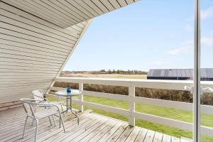 a patio with chairs and a table on a deck at 1101-Ringkobing-Rorsangervej-8 in Nørby