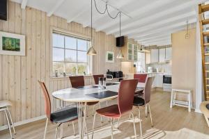 a kitchen and dining room with a table and chairs at 1101-Ringkobing-Rorsangervej-8 in Nørby