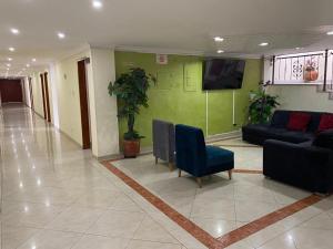 eine Lobby mit einem Sofa und einem Fernseher in einem Gebäude in der Unterkunft Hotel Nova Real in Ibagué