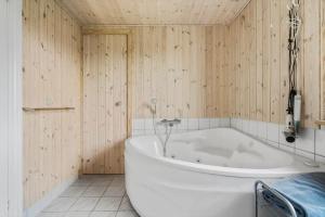 a white bath tub in a room with wooden walls at 1101-Ringkobing-Rorsangervej-8 in Nørby +19 photos