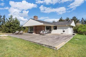 a house with a wooden deck in the yard at 1082-Ringkobing-Milevej-11 in Klegod