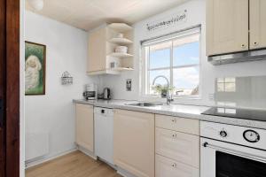 a white kitchen with a sink and a window at 179-Ringkobing-Nordsovej-236 in Søndervig +20 photos