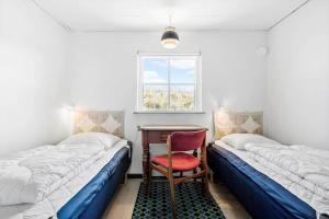 a bedroom with two beds and a desk and a chair at 179-Ringkobing-Nordsovej-236 in Søndervig
