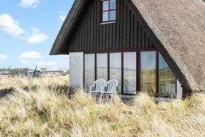 two chairs sitting in the window of a house at 179-Ringkobing-Nordsovej-236 in Søndervig