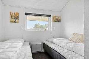 two beds in a small room with a window at 232-Ringkobing-Jakob-Bondes-Vej-35 in Klegod