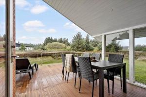 a patio with a table and chairs on a deck at 232-Ringkobing-Jakob-Bondes-Vej-35 in Klegod