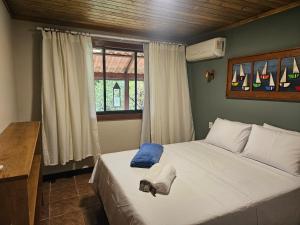 a bedroom with a large bed with a window at Green Area House in Abraão +14 photos
