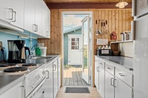 a kitchen with white cabinets and an open door at 201-Ringkobing-Fladsbjergvej-234 in Klegod