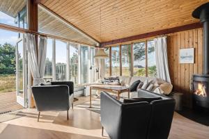 a living room with a couch and chairs and a fireplace at 201-Ringkobing-Fladsbjergvej-234 in Klegod