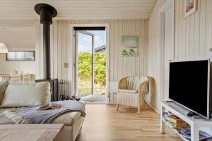 a living room with a couch and a tv at 120-Ringkobing-Sletten-15 in Søndervig