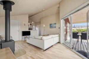 a living room with a couch and a fireplace at 120-Ringkobing-Sletten-15 in Søndervig +31 photos