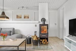 a living room with a fireplace and a couch at 292-Ringkobing-Vestklitvej-12 in Klegod