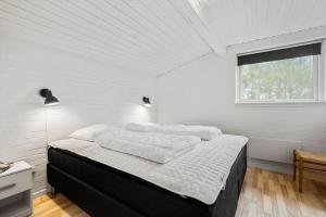 a bedroom with a large bed in a white room at 292-Ringkobing-Vestklitvej-12 in Klegod +40 photos