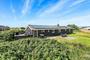 a black house with solar panels on top of it at 292-Ringkobing-Vestklitvej-12 in Klegod
