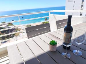 a table with a bottle of wine and a glass at Seaview Varandas do Sol 2 in Portimão