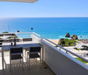 a balcony with a table and chairs and the ocean at Seaview Varandas do Sol 2 in Portimão