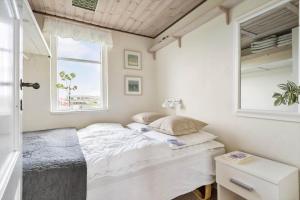 a bedroom with a white bed and a window at 1165-Ringkobing-Lodbergsvej-119 in Søndervig