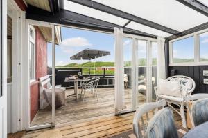 a screened in porch with a table and chairs at 1165-Ringkobing-Lodbergsvej-119 in Søndervig
