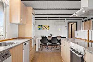 a kitchen with a table and chairs in it at 280-Ringkobing-Klitsvinget-11 in Klegod