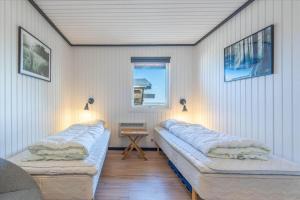 two beds in a room with a table and a window at 280-Ringkobing-Klitsvinget-11 in Klegod