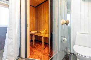 a bathroom with a shower and a toilet and a table at 280-Ringkobing-Klitsvinget-11 in Klegod +17 photos