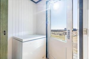a white door in a small kitchen with a window at 280-Ringkobing-Klitsvinget-11 in Klegod