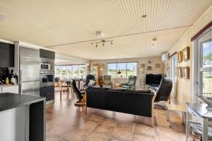 a kitchen and living room with a table and chairs at 268-Ringkobing-Lyngvejen-63 in Klegod