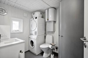 a bathroom with a washing machine and a toilet at 268-Ringkobing-Lyngvejen-63 in Klegod +25 photos