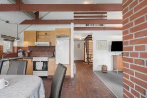 a kitchen with a table and chairs in a room at 113-Ringkobing-Ahornalle-16 in Nørby