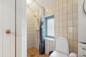 a bathroom with a shower with a toilet and a window at 113-Ringkobing-Ahornalle-16 in Nørby +40 photos