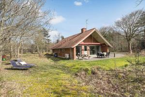 a small house with a porch and a patio at 113-Ringkobing-Ahornalle-16 in Nørby