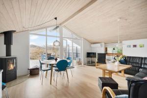 a living room with a table and chairs and a fireplace at 2253-Ringkobing-Fladsbjergvej-234-E in Klegod +29 photos