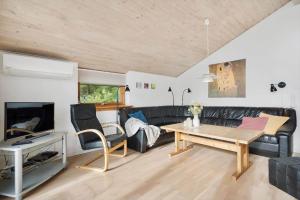 a living room with a black couch and a table at 2253-Ringkobing-Fladsbjergvej-234-E in Klegod