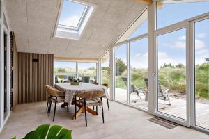 a dining room with a table and some windows at 2253-Ringkobing-Fladsbjergvej-234-E in Klegod