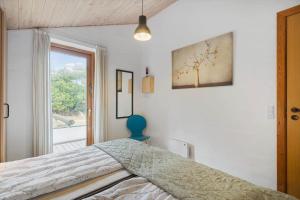 a bedroom with a bed and a window at 2253-Ringkobing-Fladsbjergvej-234-E in Klegod