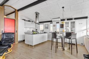 a kitchen with white cabinets and black chairs in it at 1149-Ringkobing-Holmsborgvej-32 in Søndervig
