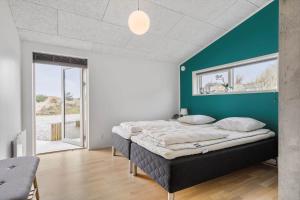 a bedroom with a bed and a green wall at 1149-Ringkobing-Holmsborgvej-32 in Søndervig