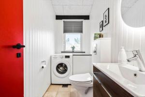 a bathroom with a washing machine and a sink at 1149-Ringkobing-Holmsborgvej-32 in Søndervig +21 photos