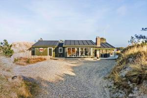 a house with a black roof on a gravel road at 1149-Ringkobing-Holmsborgvej-32 in Søndervig