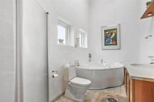 a bathroom with a tub and a toilet and a sink at 138-Ringkobing-Sondervig-Klitvej-3 in Søndervig +25 photos